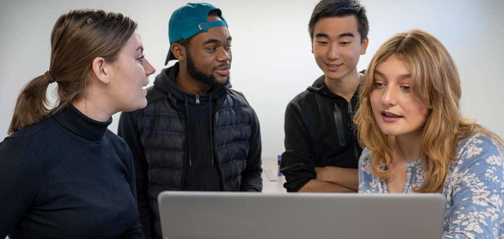 4 students around a laptop